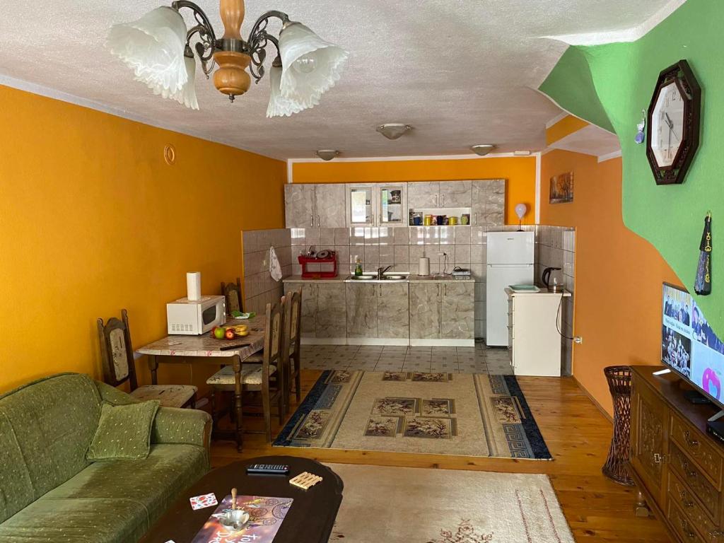 a living room with a green couch and a kitchen at Apartment Cuni in Mostar