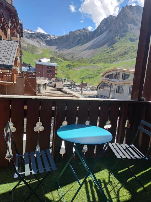 a table and chairs on a balcony with a view of a mountain at CHALET CLUB VAL CLARET in Tignes