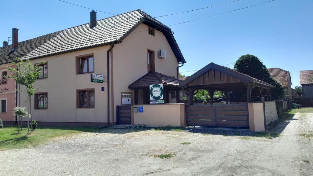 ein großes weißes Haus mit einem Holztor in der Unterkunft Apartman kod Kraljevih in Gola