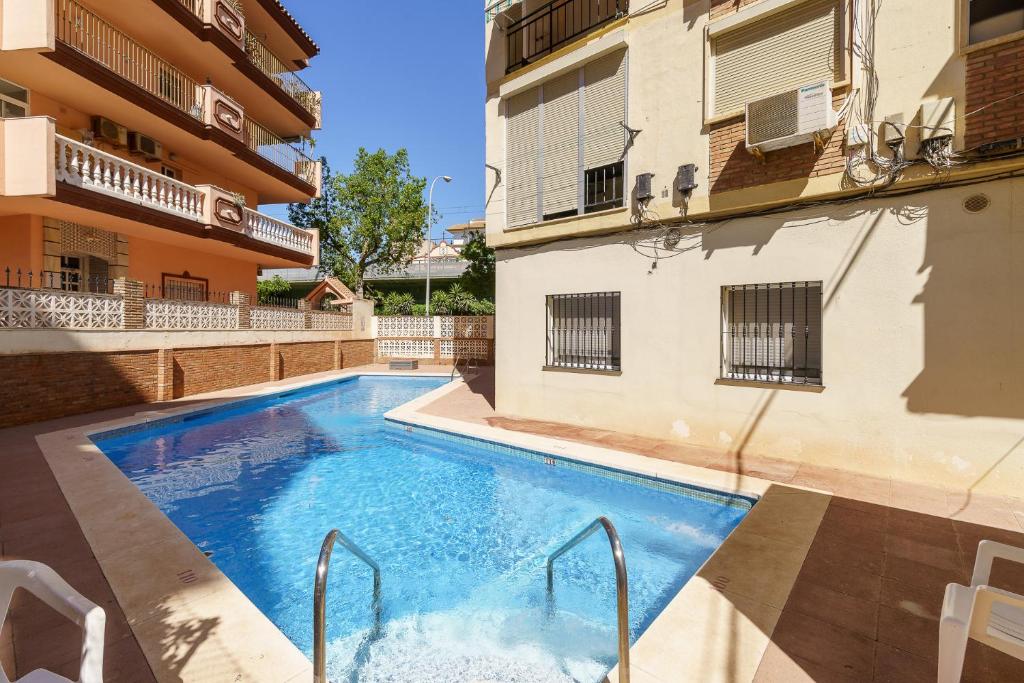 a swimming pool in front of a building at CT 178 - Versalles City Apartment - Fuengirola in Fuengirola