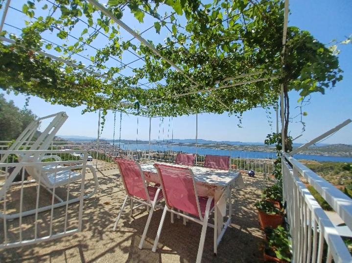 una mesa y sillas en un patio con vistas al océano en Apartment Paolo, en Šibenik
