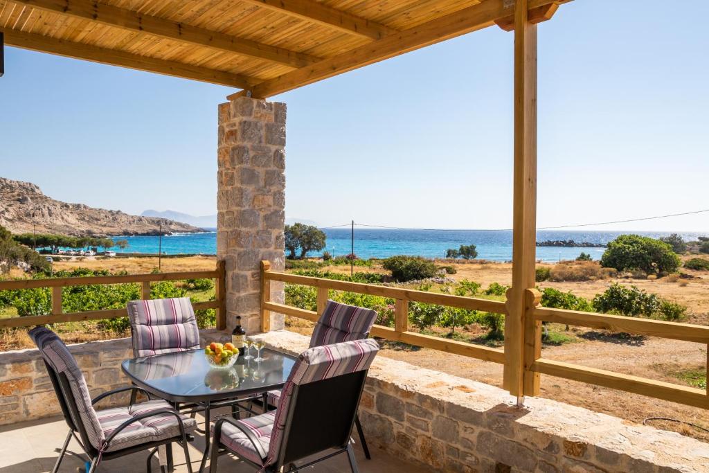 a patio with a table and chairs and a view of the ocean at Venetia's apartments in Karpathos Town
