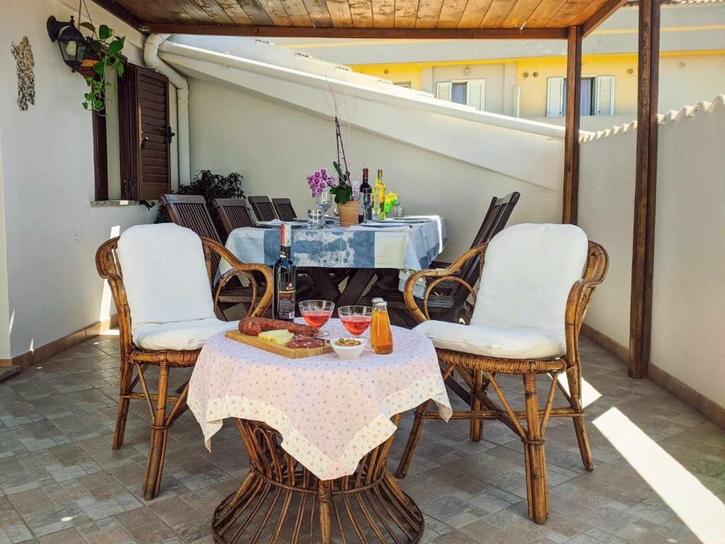 stół i krzesła na patio w obiekcie Appartamento vicino spiaggia di Maria Pia 4 camere 4 bagni per 9 persone w mieście Alghero