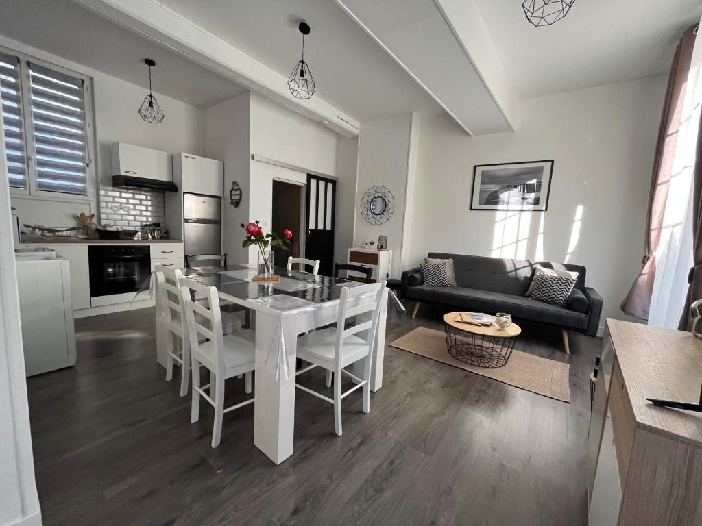 cocina y sala de estar con mesa blanca y sillas en Le Gîte du Petit Buccin à 2 mn de la mer. en Dieppe