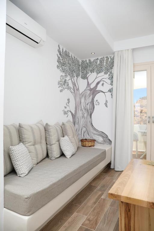 a living room with a couch with a tree mural on the wall at GRΕΛΙΑ ΗΟΜΕ in Naxos Chora