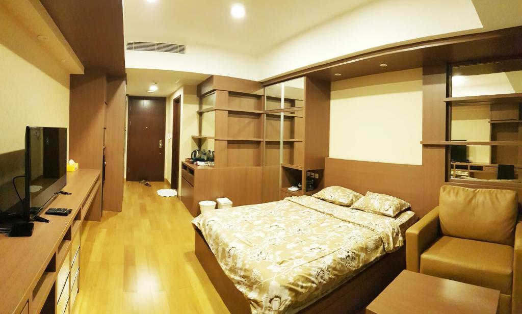1 dormitorio con 1 cama, TV y silla en U Residence Tower2 Supermal Lippo Karawaci, en Klapadua