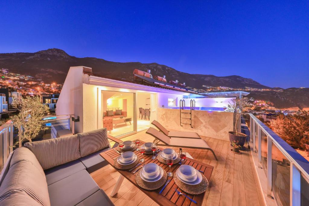 eine Terrasse mit einem Sofa und einem Tisch auf dem Balkon in der Unterkunft Olive View Penthouse in Kalkan