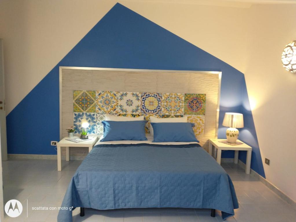 a blue bedroom with a large bed with blue walls at IDA S Apartament in Pontecagnano