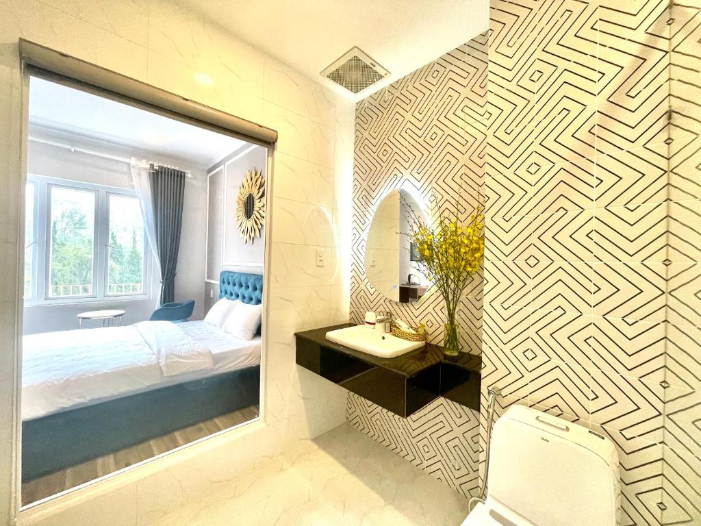 a bedroom with a mirror and a bed and a sink at Phuong Vy Luxury Hotel in Da Lat