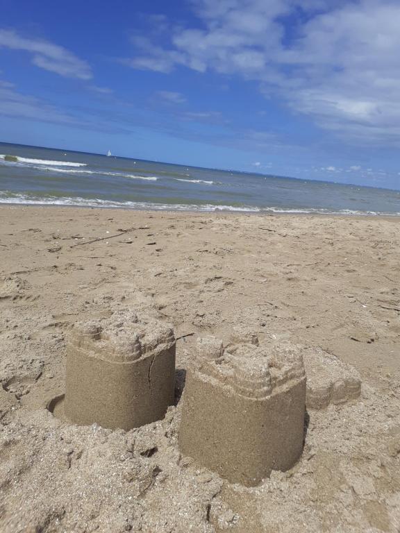 a sand castle on a beach with the ocean at L'annexe in Cabourg