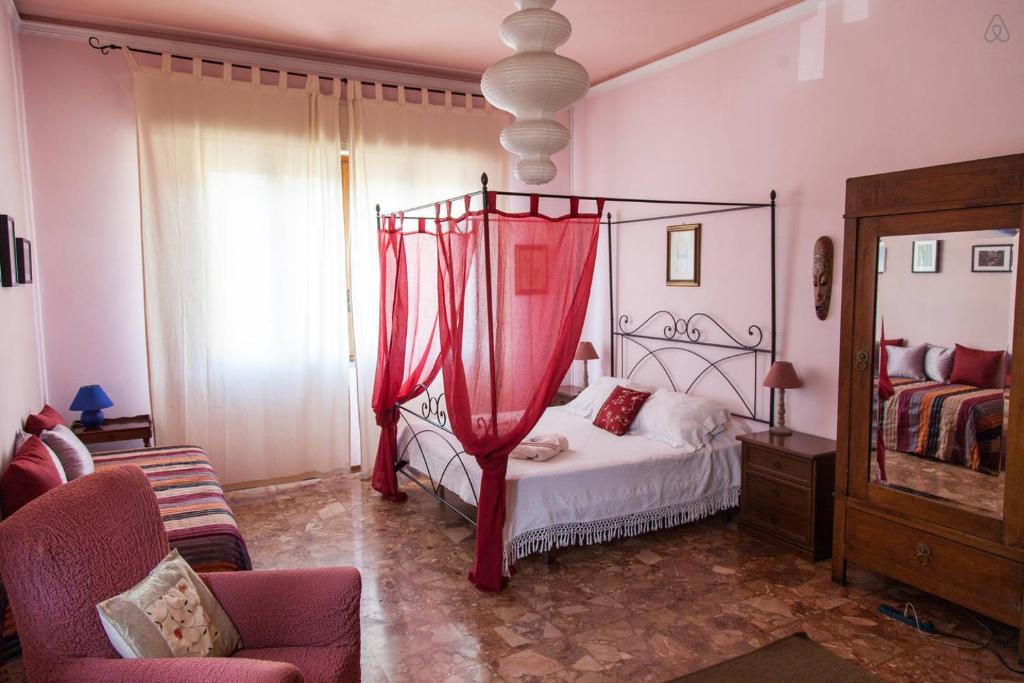 a bedroom with a bed with a red canopy at Il Ramingo in Lucca