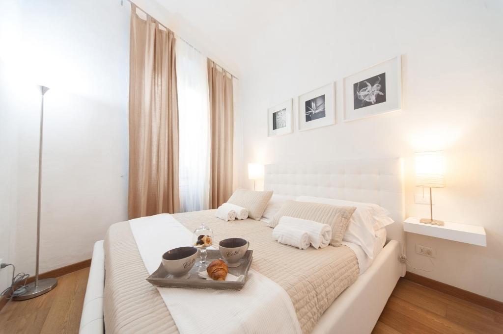フィレンツェにあるプリンチピ アパートメントの白いベッドルーム(ベッド、食料トレイ付)