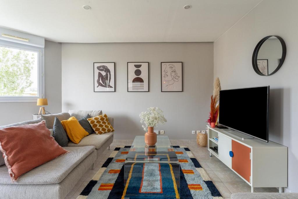 a living room with a couch and a tv at SIROCCO - Bel appartement avec extérieur proche des plages in Marseille