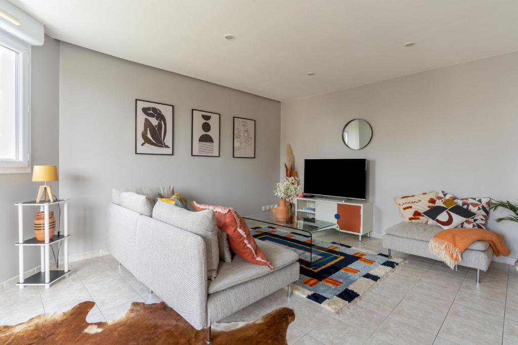 a living room with a couch and a tv at SIROCCO - Bel appartement avec extérieur proche des plages in Marseille