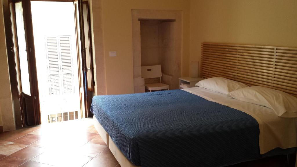 a bedroom with a large bed with a blue blanket at Iblea Paradise in Ragusa
