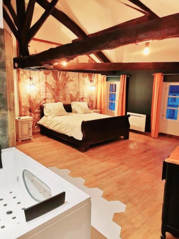 a large bedroom with a large bed and a sink at Suite Penthouse Romantique avec Jacuzzi, Confolens, Charente in Confolens