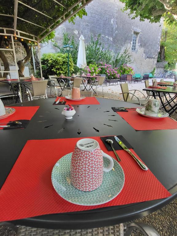 a table with red napkins and a coffee cup on it at Logis Hotel Restaurant la Ferme in Avignon