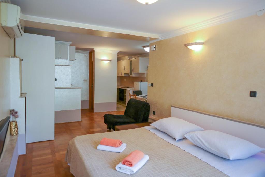 1 dormitorio con 1 cama con 2 toallas en Apartments Okuka en Split
