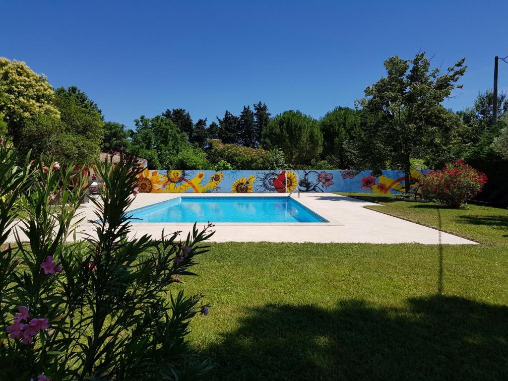 - une piscine dans une cour ornée d'une fresque murale dans l'établissement Logis Hotel la Ferme, à Avignon