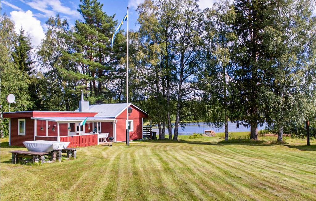 una casa roja con una mesa de picnic delante de ella en Cozy Home In Strmsund With Lake View en Strömsund