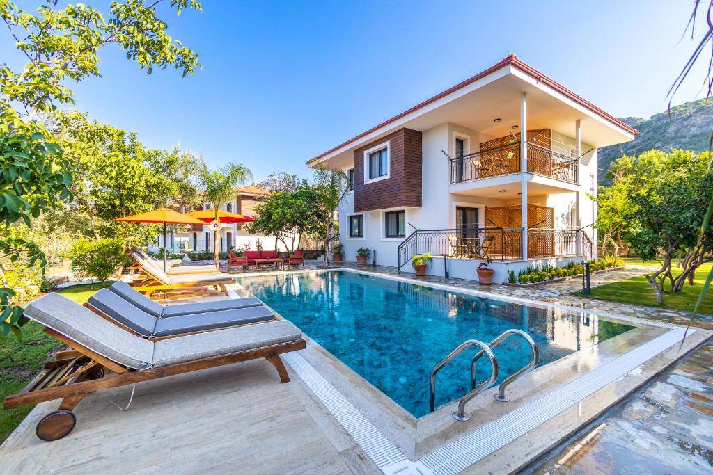 a villa with a swimming pool and a house at Elizya Boutique Hotel in Selimiye