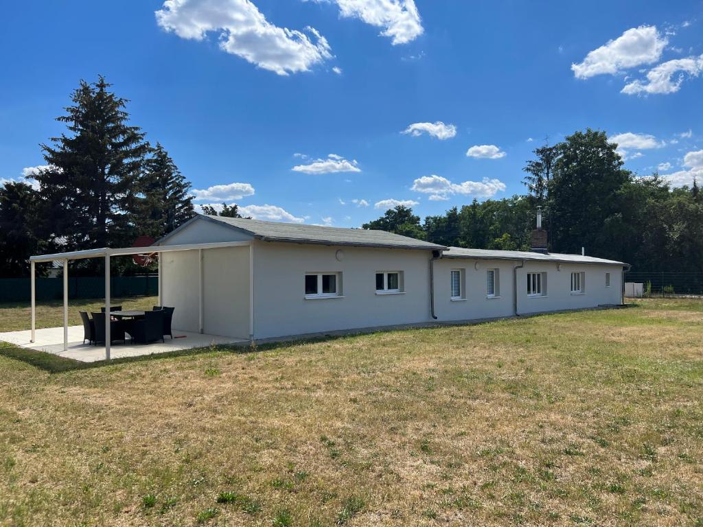 ein großes weißes Gebäude auf einem Feld in der Unterkunft Platz für die ganze Familie - Bungalow mit großem Grundstück in Leipzig