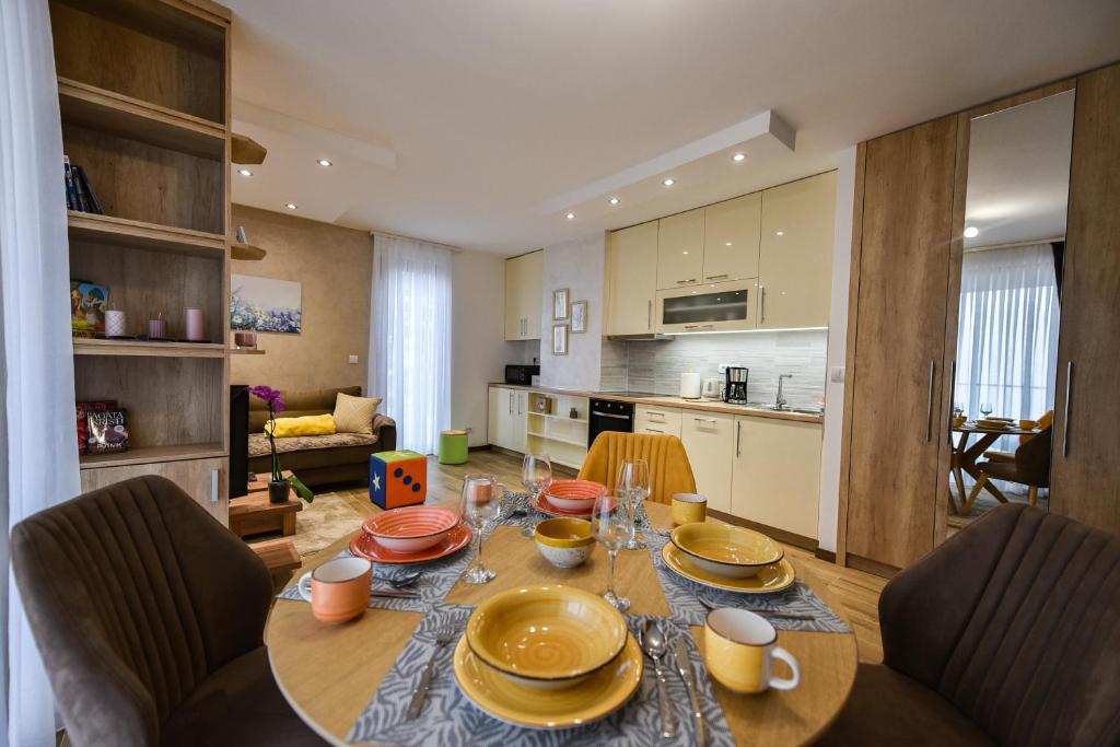 een keuken en eetkamer met een tafel en stoelen bij Apartman Oblačak Divčibare in Divčibare