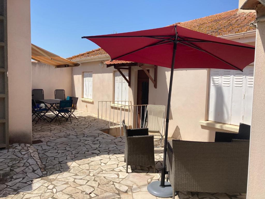 een rode paraplu bovenop een patio bij Gîte domaine de la source bas in Vias