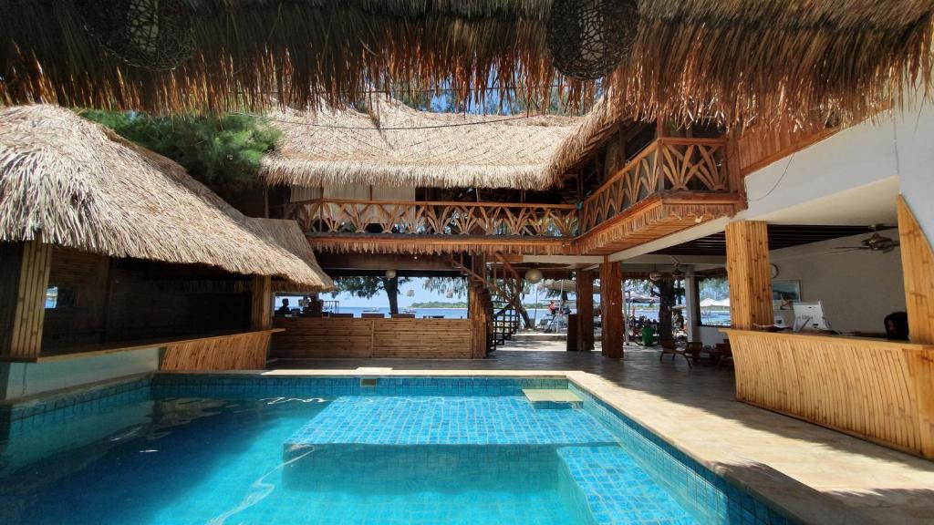 een zwembad tegenover een resort met een gebouw bij Samba Villas Beachfront View in Gili Trawangan