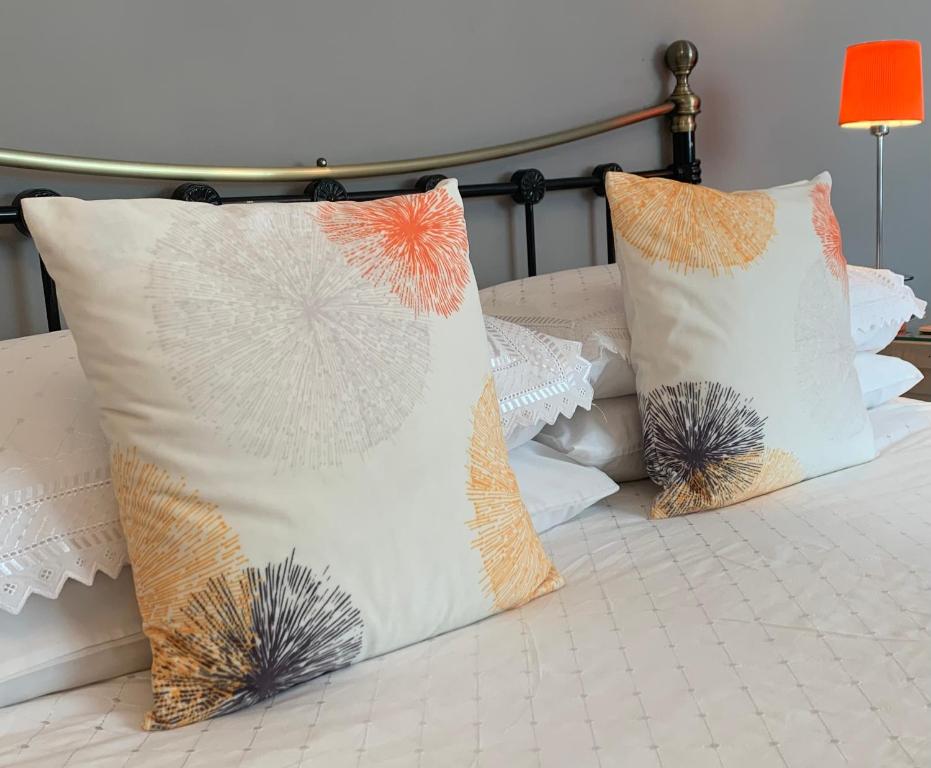 a group of pillows sitting on top of a bed at The Coast Yard B & B and Garden Chalets in Selsey