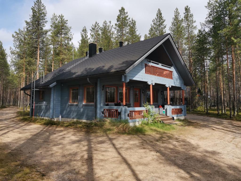 a blue house in the middle of a forest at Sininen Hetki Cottage in Kuusamo
