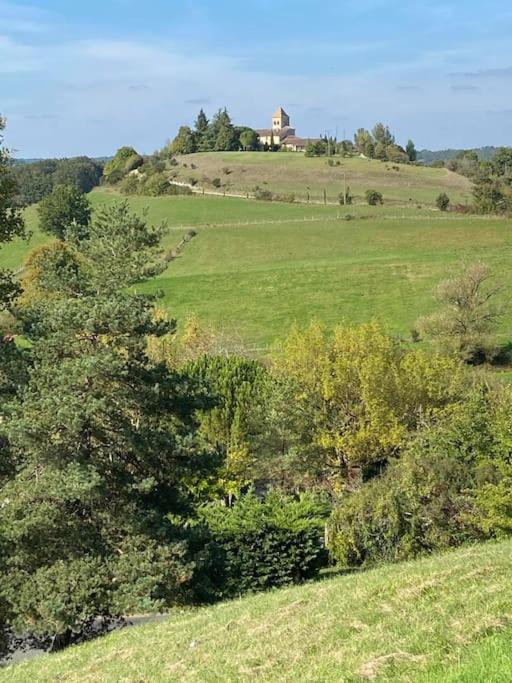 a green field with a house on top of a hill at Claire fontaine in Beaumont-du-Périgord
