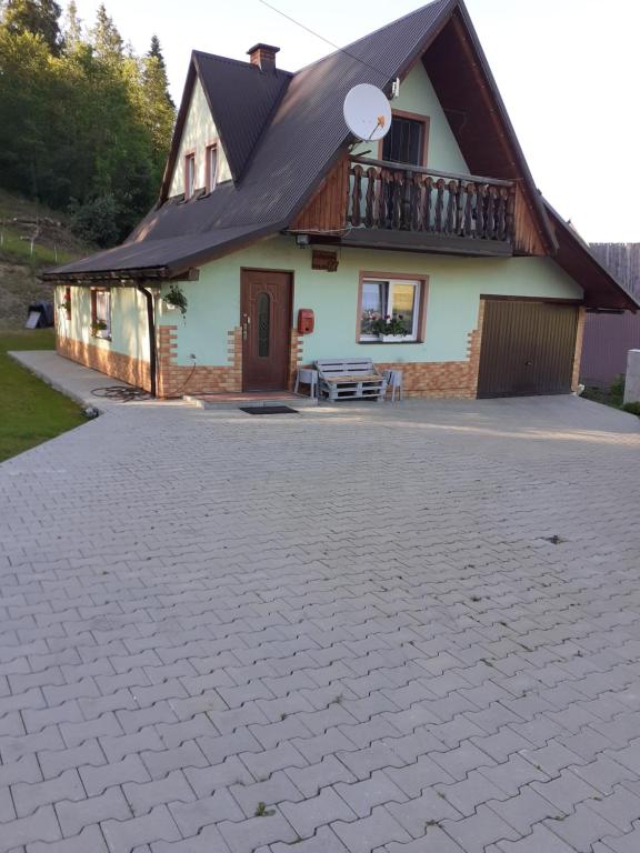 a house with a black roof and a driveway at Domek u Zosi in Gliczarów