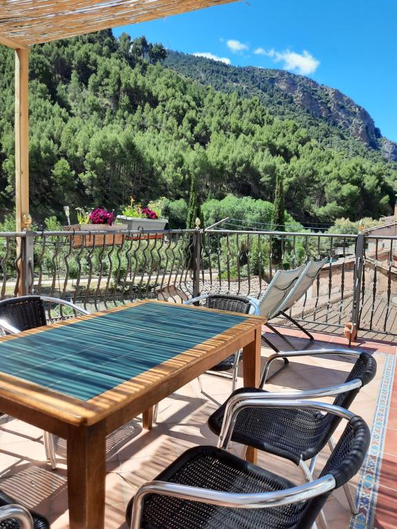 a wooden table and chairs on a balcony with a mountain at La Fuente de Arnedillo in Arnedillo