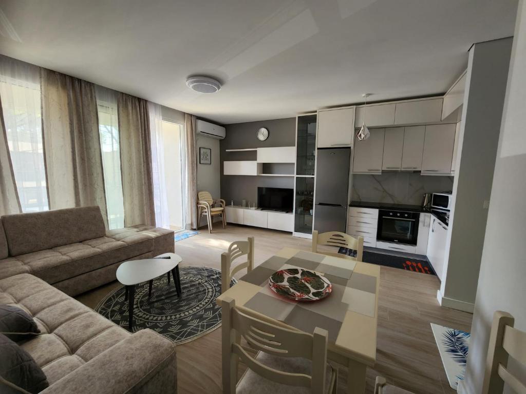 un soggiorno con divano e tavolo di Lovely 1-Bedroom Apartment at San Pietro Beach Front Resort a Mullini i Danit