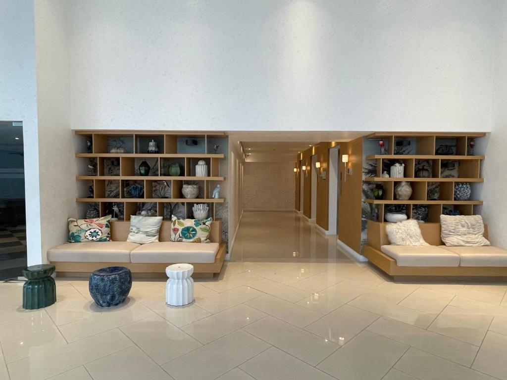 a lobby with couches and shelves of vases at Chic Hideaway at Azure North Bali Tower in San Fernando