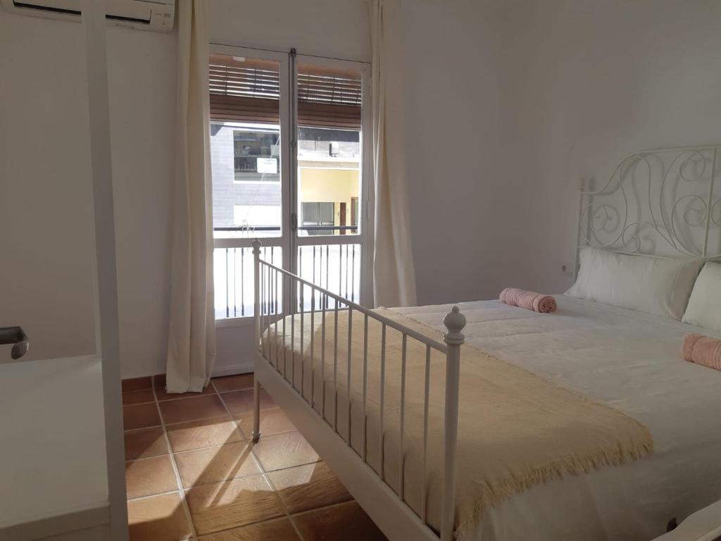 Un dormitorio con una cama y una ventana grande. en Moderna casa de pueblo en el casco viejo de Jávea, en Jávea