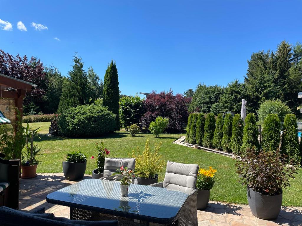 eine Terrasse mit einem Tisch und Stühlen sowie einem Garten in der Unterkunft Zum Geigenmüller in Stützengrün