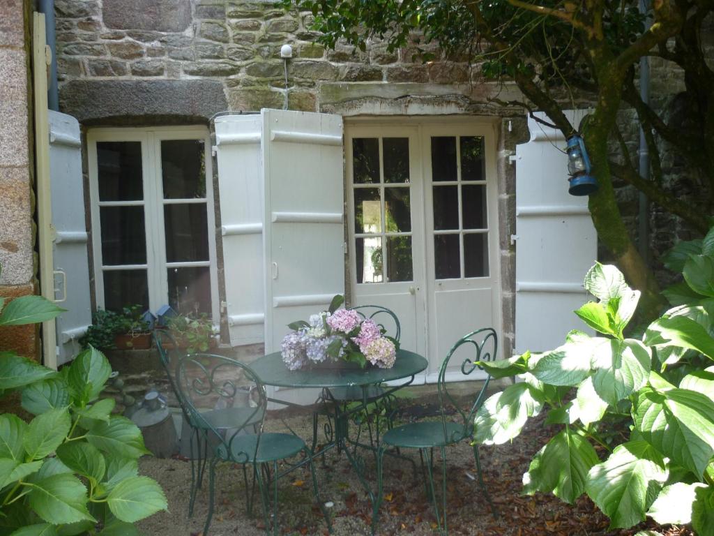 stół i krzesła przed budynkiem w obiekcie La Maison de Claire w mieście Val Couesnon