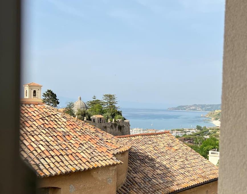 a view of roofs of buildings with the ocean in the background at Boutique Apartment - Tropea in Tropea