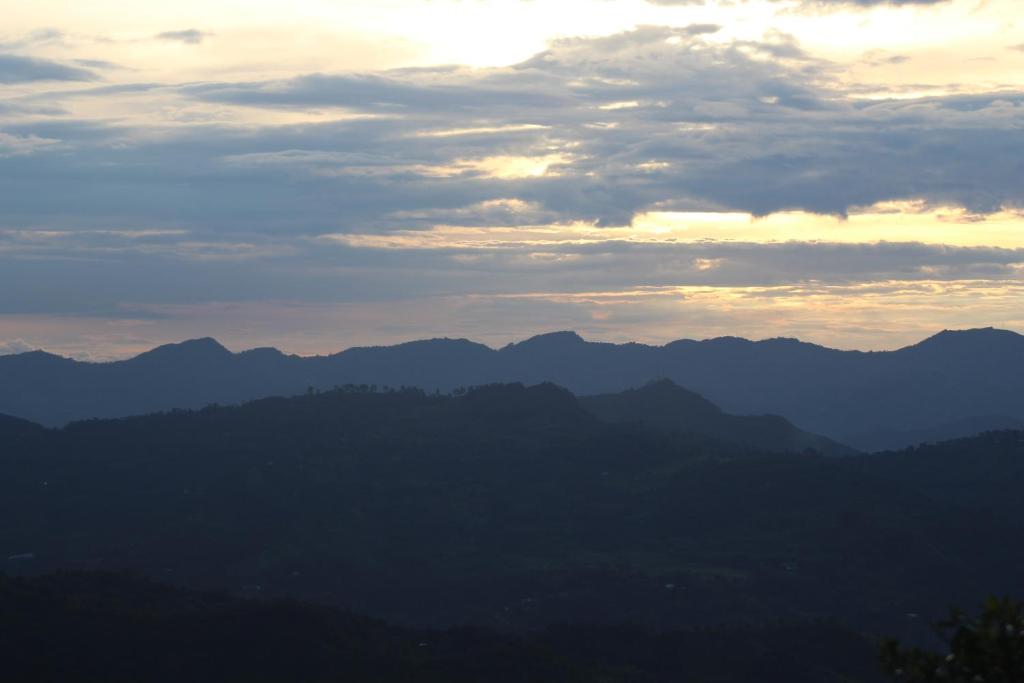 a view of a mountain range at sunset at el paraíso de Butulú 1 in La Vega