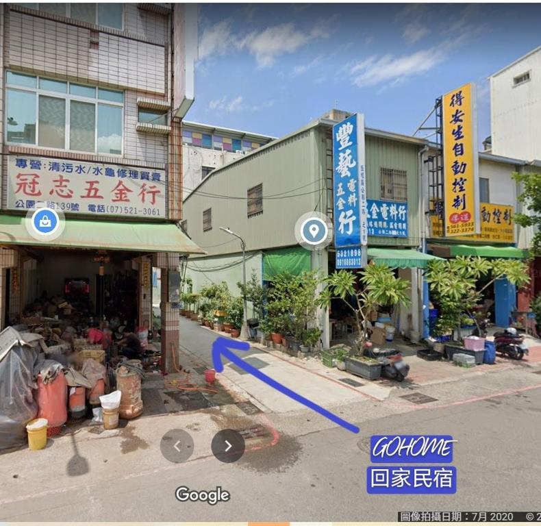 un groupe de bâtiments avec panneaux dans une rue dans l'établissement Go Home Homestay, à Kaohsiung