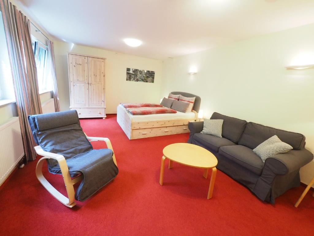 ein Wohnzimmer mit einem Sofa, einem Tisch und einem Bett in der Unterkunft B&B Casa20 Dieburg in Dieburg