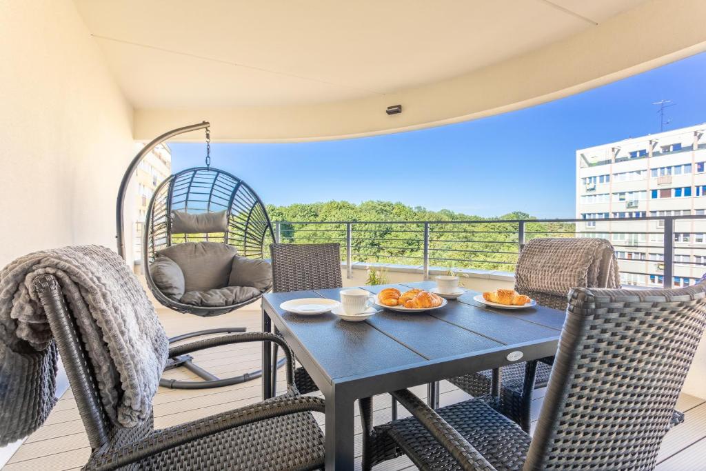 a patio with a table and chairs on a balcony at Ambria Apartments Sun Towers in Świnoujście