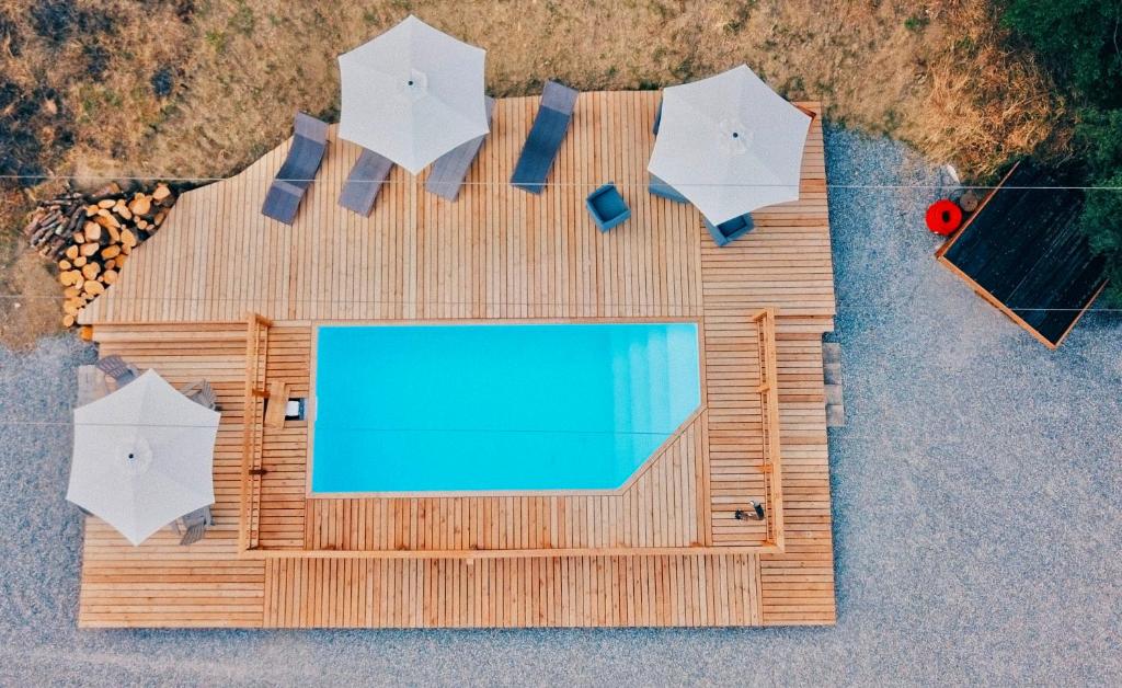 an overhead view of a pool with chairs and umbrellas at Chaletdesilles MAYOTTE IIIII in Prat-et-Bonrepaux