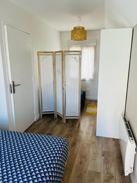 pokój z czterema drzwiami i łóżkiem w środku w obiekcie La maison des hirondelles w mieście Berck-sur-Mer