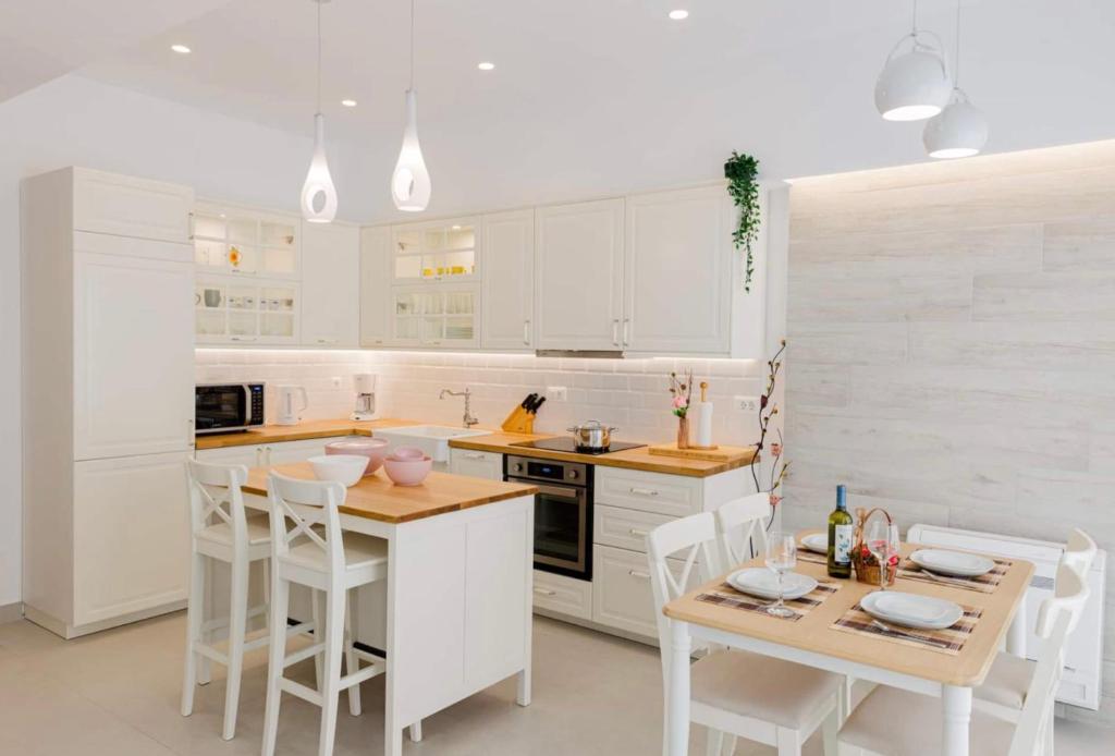 a kitchen with white cabinets and a table and chairs at Old town luxury apartment in Kos Town