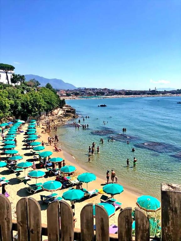 a beach with umbrellas and people in the water at In Vacanza a Gaeta - Il Nido dell'Artista in Gaeta