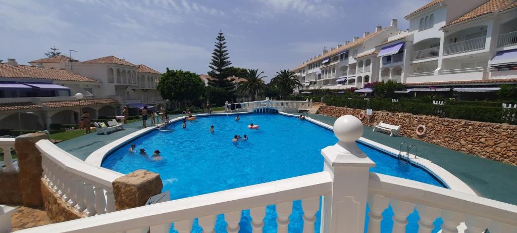 a large swimming pool with people in the water at Alcossebre RESIDENCIAL ALANDALUS 5002 in Alcossebre