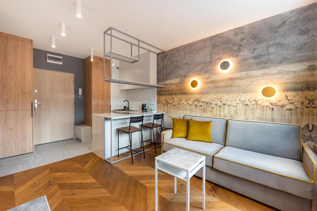 ein Wohnzimmer mit einem Sofa und einer Küche in der Unterkunft Nowa Praga Geometric Yellow Apartment in Warschau